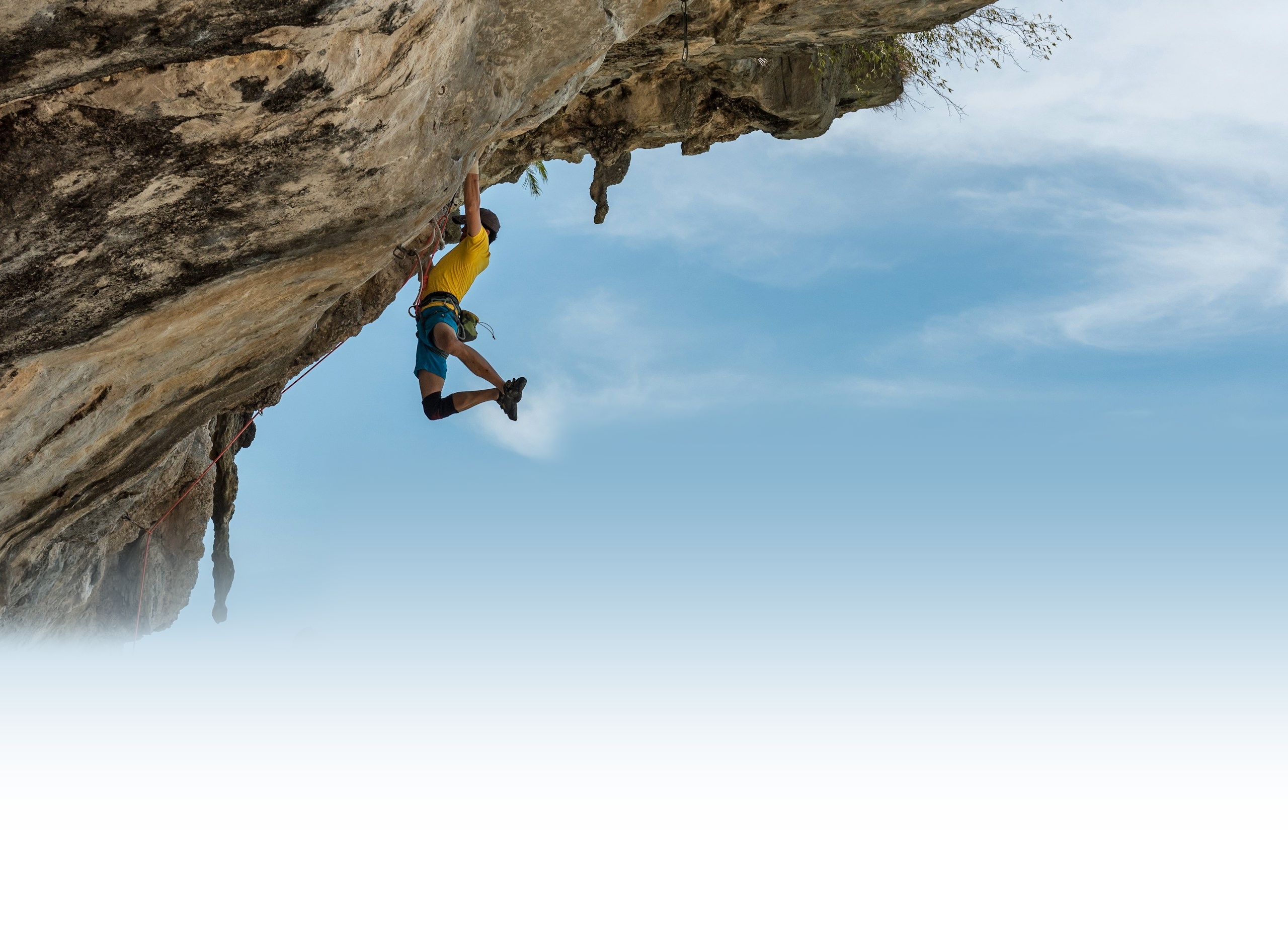 Rock climber scaling vertical rock overhang with supreme focus and composure